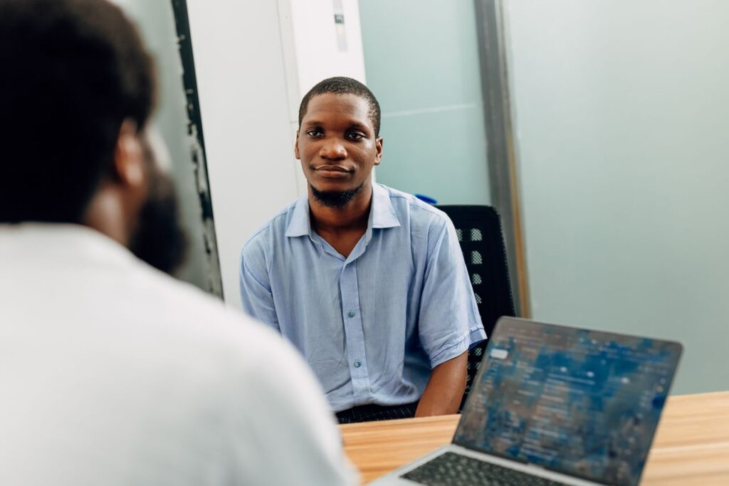 Mastering the First Impression: Your intriguing post title goes here A business meeting in a modern office in Lagos, Nigeria featuring two professionals engaged in a discussion.